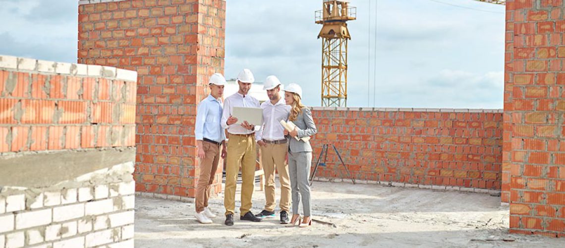 profissionais da construcao civil observando planta com automatizacao de processos